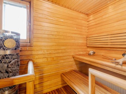 a wooden sauna with a dog sitting on a ledge at Santa's Hotel Santa Claus in Rovaniemi