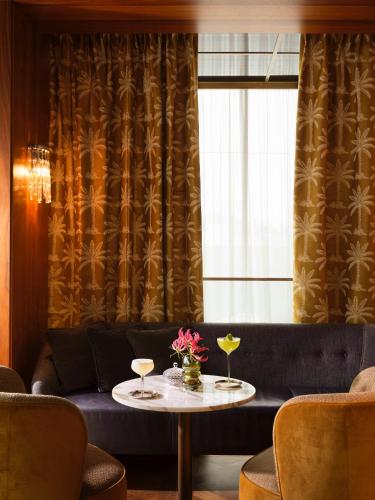 a living room with a couch and a table with drinks at Rosewood Vienna in Vienna