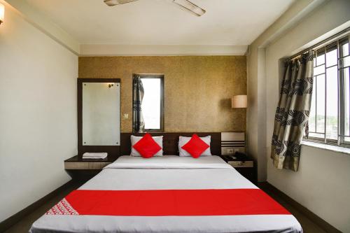 a bedroom with a large bed with red pillows at Hotel O New Tulip Santragachi Junction in Kolkata