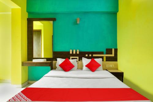 a bedroom with a bed with red and green walls at Hotel O New Tulip Santragachi Junction in Kolkata