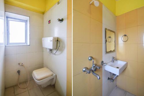 a bathroom with a toilet and a sink at Hotel O New Tulip Santragachi Junction in Kolkata