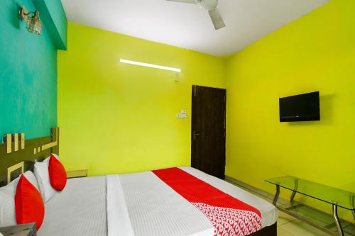 a bedroom with a bed and a tv on the wall at Hotel O New Tulip Santragachi Junction in Kolkata