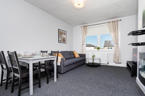 a living room with a couch and a table at 3 Bedroom Flat - Free Parking in Falkirk