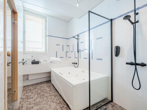 a white bathroom with a tub and a shower at Santa's Hotel Santa Claus in Rovaniemi