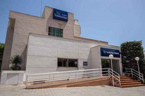 a building with a sign on the side of it at Travelodge Alicante Puerto in Alicante