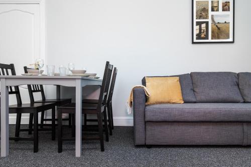 a dining room with a table and a couch at 3 Bedroom Flat - Free Parking in Falkirk