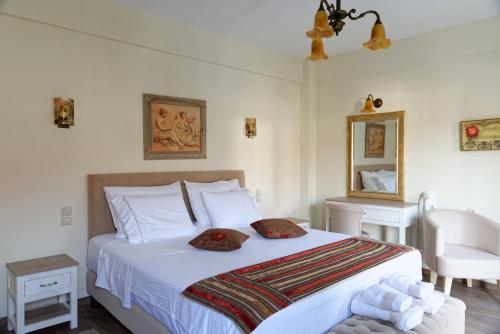 um quarto com uma cama branca com duas almofadas em Alexandra Hotel em Kalentzi