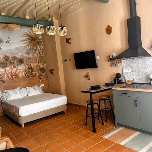a bedroom with a bed and a table and a kitchen at ANJ Alojamientos in Guadalupe