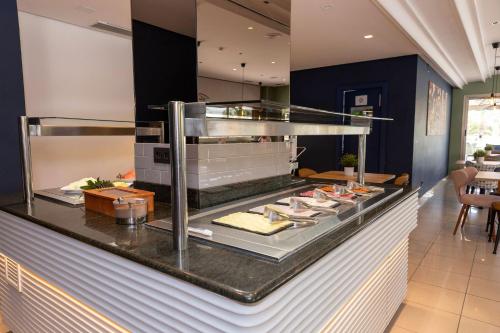 a buffet in a restaurant with food on a counter at Travelodge Alicante Puerto in Alicante
