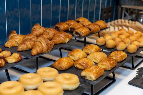 a bunch of pastries on trays in a bakery at Travelodge Alicante Puerto in Alicante