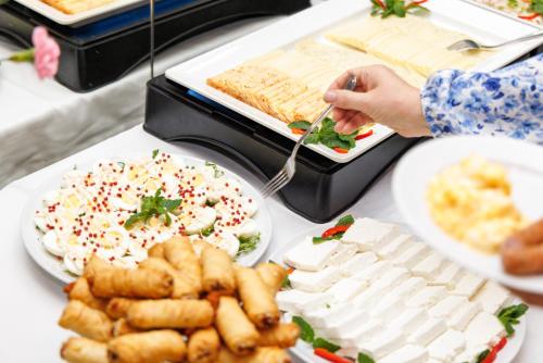 a table topped with plates of food with food at Hotel Echo in Cedzyna