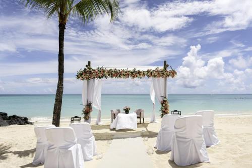 a wedding arch on the beach with chairs and a table at Royal Palm Beachcomber Luxury in Grand Baie