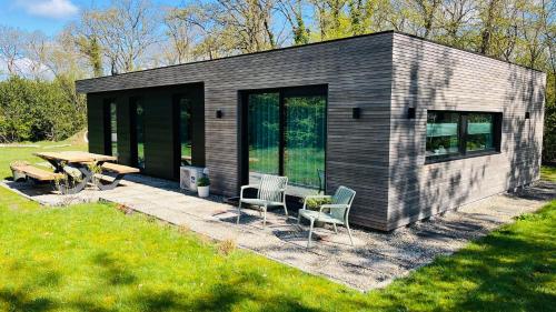 a small house with a picnic table and chairs at Vakantiegeluk in Zorgvlied