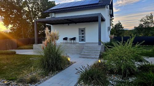 a white house with two stools in a yard at Casa Cordis in Korduševci