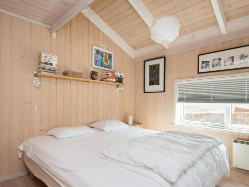 a bedroom with a white bed and a window at 4 star holiday home in Ebeltoft in Ebeltoft