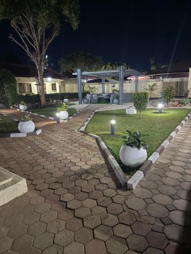 a stone walkway with plants in a courtyard at night at Java Tree Cottage in Lusaka
