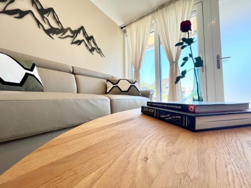 a stack of books sitting on a coffee table in a living room at Lake and Trail, Free Parking, Near Nature and City in Neuchâtel