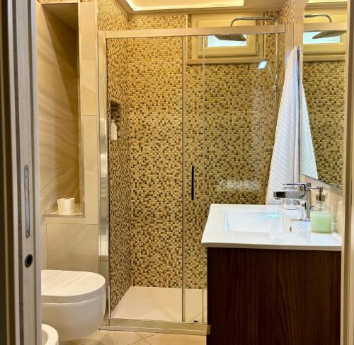 a bathroom with a shower with a sink and a toilet at Le Cale' B&B in San Severo