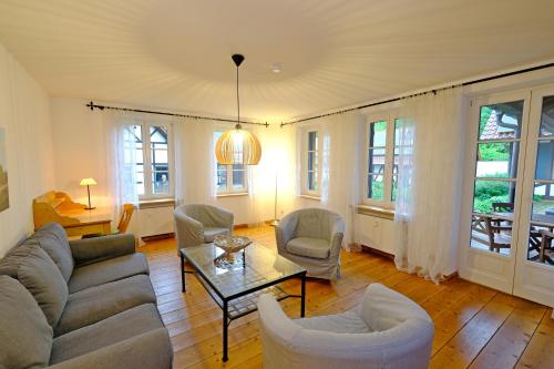 a living room with a couch and chairs and a table at Hotel Gut Klostermühle natur resort & medical spa in Alt Madlitz