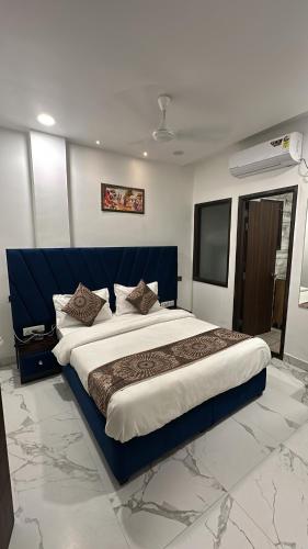 a bedroom with a large bed with a blue headboard at Hotel Prim Rose in Amritsar