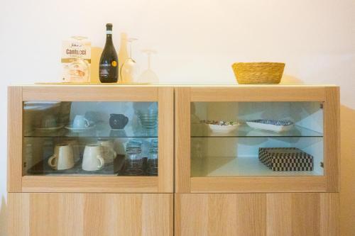 a wooden cabinet with two glass doors with dishes at Direttamente sul lungomare in Pescara