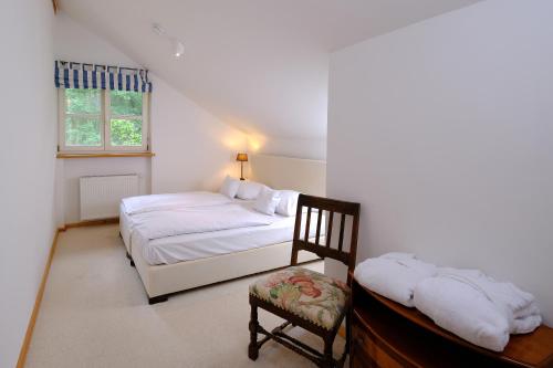 a bedroom with a bed and a chair and a window at Hotel Gut Klostermühle natur resort & medical spa in Alt Madlitz