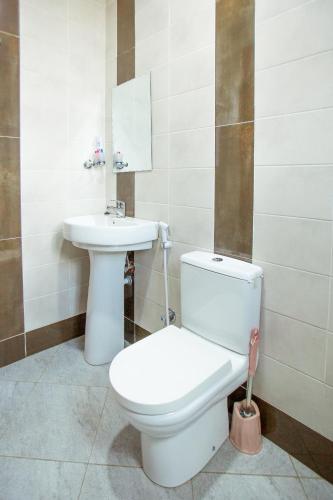 a bathroom with a toilet and a sink at Sarnah Apartments in Arusha