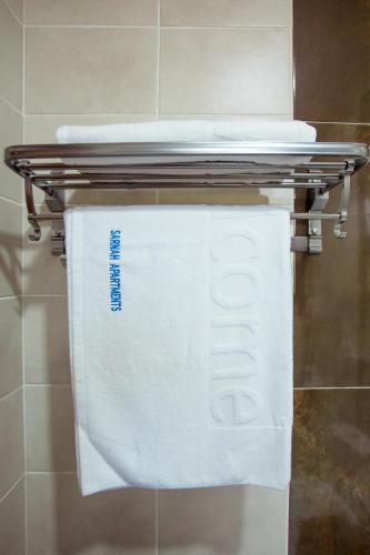 a towel rack with white towels on it in a bathroom at Sarnah Apartments in Arusha