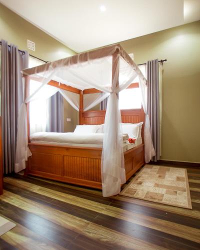 a bedroom with a bed with a canopy at Sarnah Apartments in Arusha