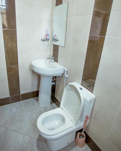 a bathroom with a toilet and a sink at Sarnah Apartments in Arusha