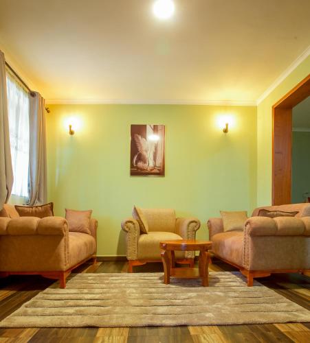 a living room with two couches and a table at Sarnah Apartments in Arusha
