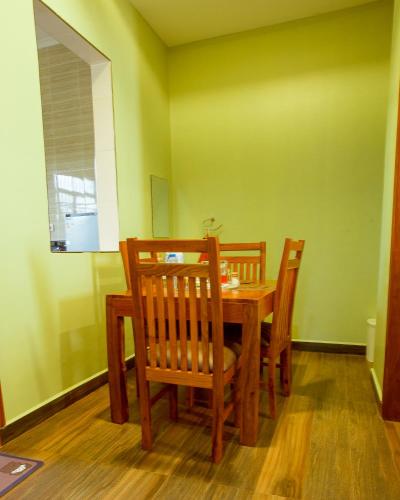 a dining room with a wooden table and chairs at Sarnah Apartments in Arusha