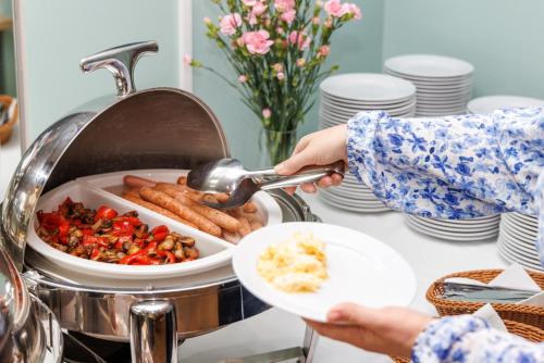 a person is getting food from a buffet at Hotel Echo in Cedzyna