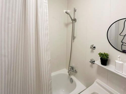 Baño blanco con cortina de ducha y lavamanos en Bright Modern Apartment in Mülheim an der Ruhr, en Mülheim an der Ruhr