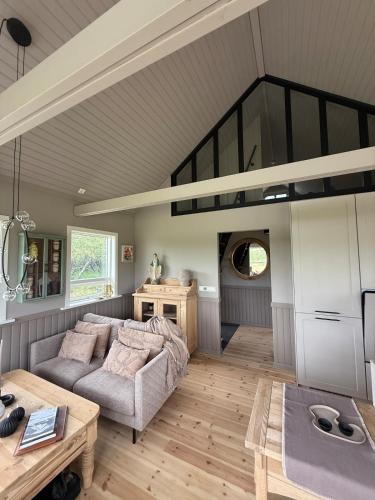 a living room with a couch and a table at Luxurious Cabin with Hot tub in Stóri-Ás