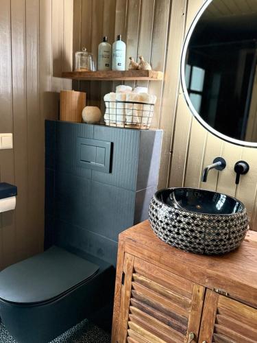 a bathroom with a black sink and a mirror at Luxurious Cabin with Hot tub in Stóri-Ás