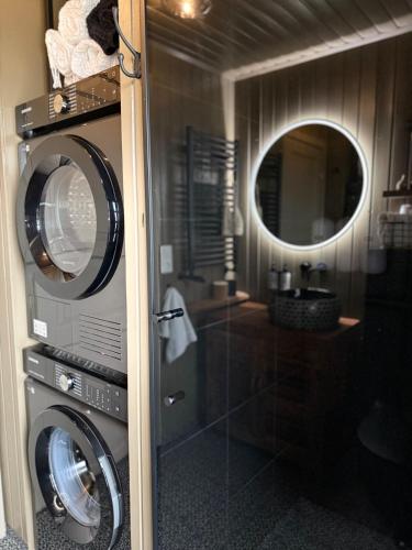 a bathroom with two washing machines and a mirror at Luxurious Cabin with Hot tub in Stóri-Ás
