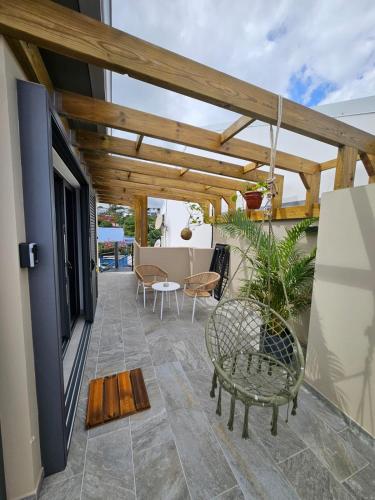 a patio with a wooden pergola and a table and chairs at joly brise in Saint-Pierre