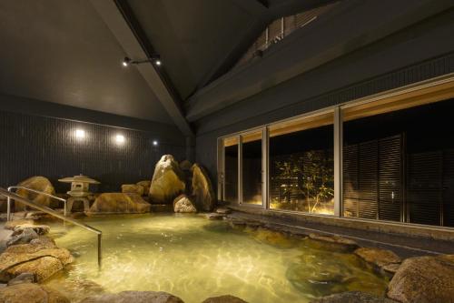 a large pool of water in a room with rocks at TAOYA Nachikatsuura in Nachikatsuura