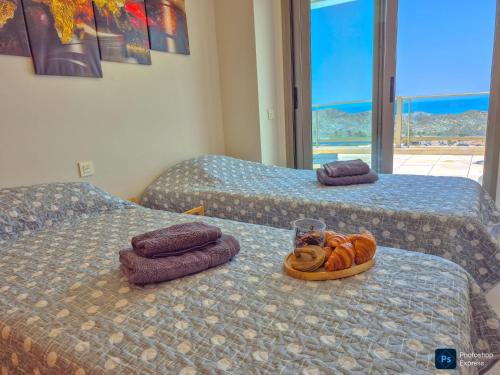 two beds with towels and a tray of donuts on them at Soleil-Sérénité Golf Aguilón in Pilar de Jaravía