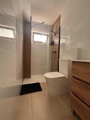 a white bathroom with a toilet and a shower at Apartamentos RoMar Campillos in Campillos