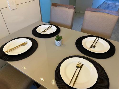 a table with plates and forks and napkins on it at Casa 02 - Casa com 2 quartos, próximo a rodoviária e aeroporto in Palmas