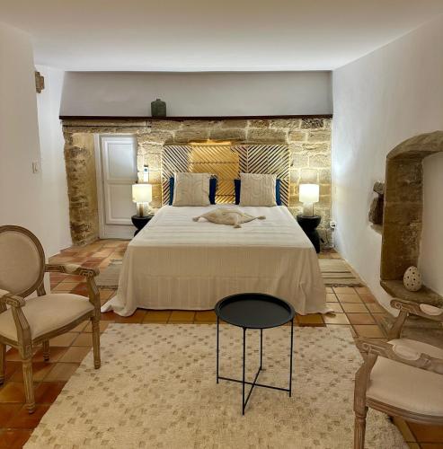 a bedroom with a large bed and two chairs at Le Clos du Vialle in Grillon