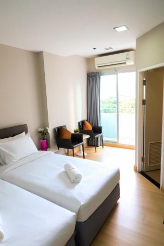 a hotel room with two beds and a living room at CU iHouse เรือนวิรัชมิตร in Bang Rak
