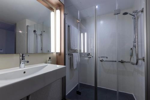 a bathroom with a sink and a glass shower at Travelodge Málaga Airport in Málaga