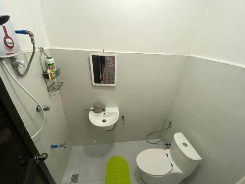a white bathroom with a toilet and a sink at Cozy Home in Malaybalay 2 Bedrooms and 1 Bathroom in Malaybalay
