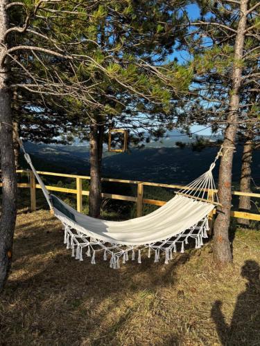 a hammock hanging from two trees next to a fence at Bubble Room Experience in Casteldelci