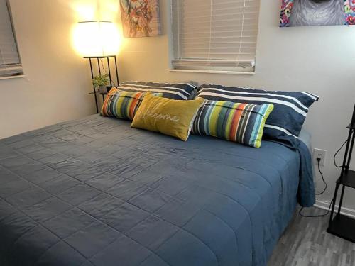 a bed with blue sheets and pillows in a room at Pool Beach House in New Port Richey
