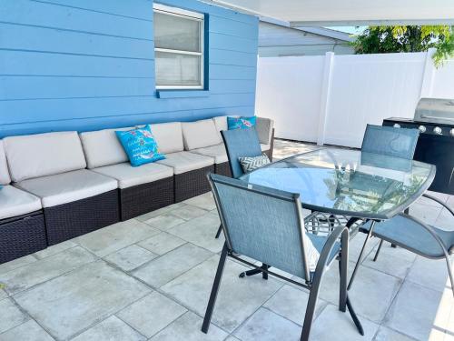 a patio with a couch and a glass table and chairs at Pool Beach House in New Port Richey