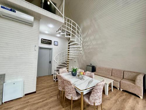 Una habitación con una mesa y sillas y una escalera. en Quba A frame, en Mekhrably